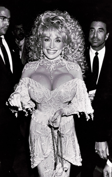 Image may contain Dolly Parton Sandy Gallin Person Fashion Clothing Dress Adult Wedding Formal Wear and Accessories