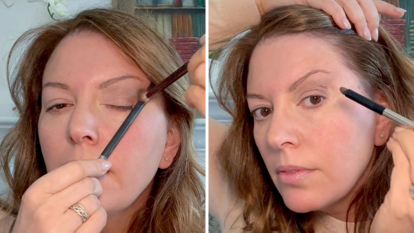 woman applying dark eye shadow to her outer crease to make eyes look more open